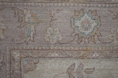A close-up of a handwoven Afghan Chobi rug featuring traditional floral patterns in muted tones.