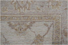 A close-up of a handwoven Afghan Chobi rug featuring traditional patterns in neutral wood tones.