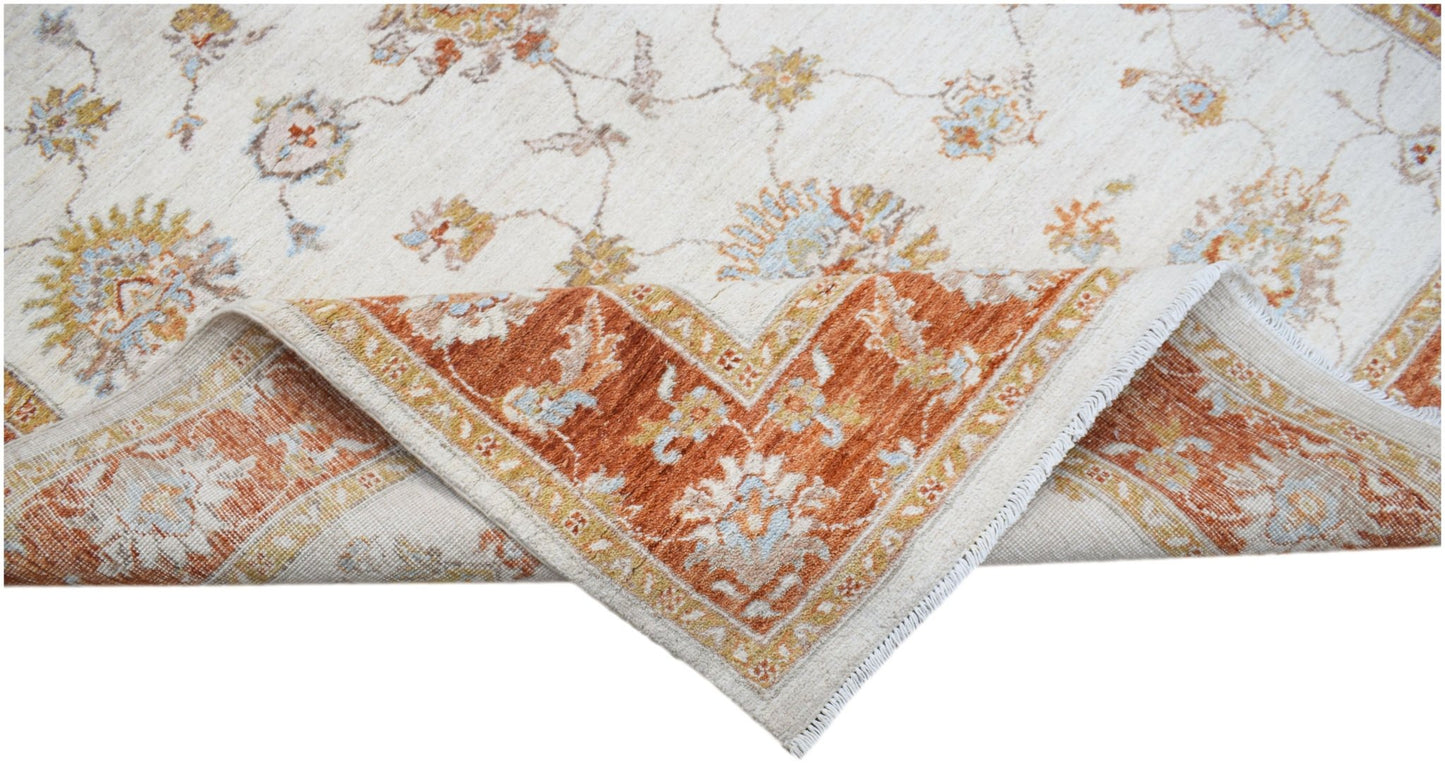 A handwoven Afghan Chobi rug with a cream field and a rust-colored floral border.