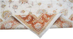 A handwoven Afghan Chobi rug with a cream field and a rust-colored floral border.