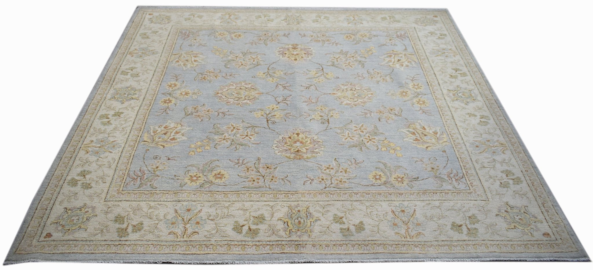 A rectangular Afghan Chobi rug featuring a light blue field with floral patterns and a beige border.