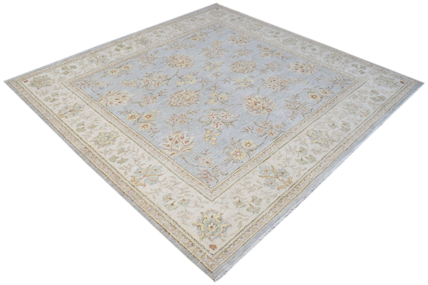 A square Afghan Chobi rug featuring a light blue field with traditional floral patterns.