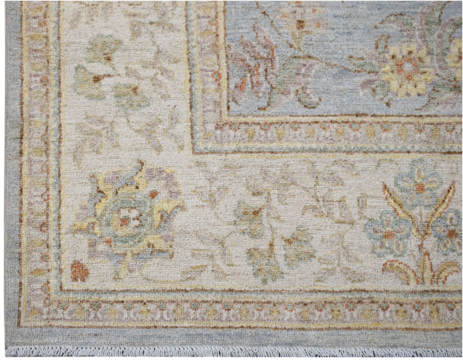 A handwoven Afghan Chobi rug featuring a floral pattern in soft blue, cream, and earthy tones.