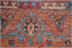 A close-up of an Afghan Chobi rug featuring intricate floral patterns in blue, red, and tan wool.