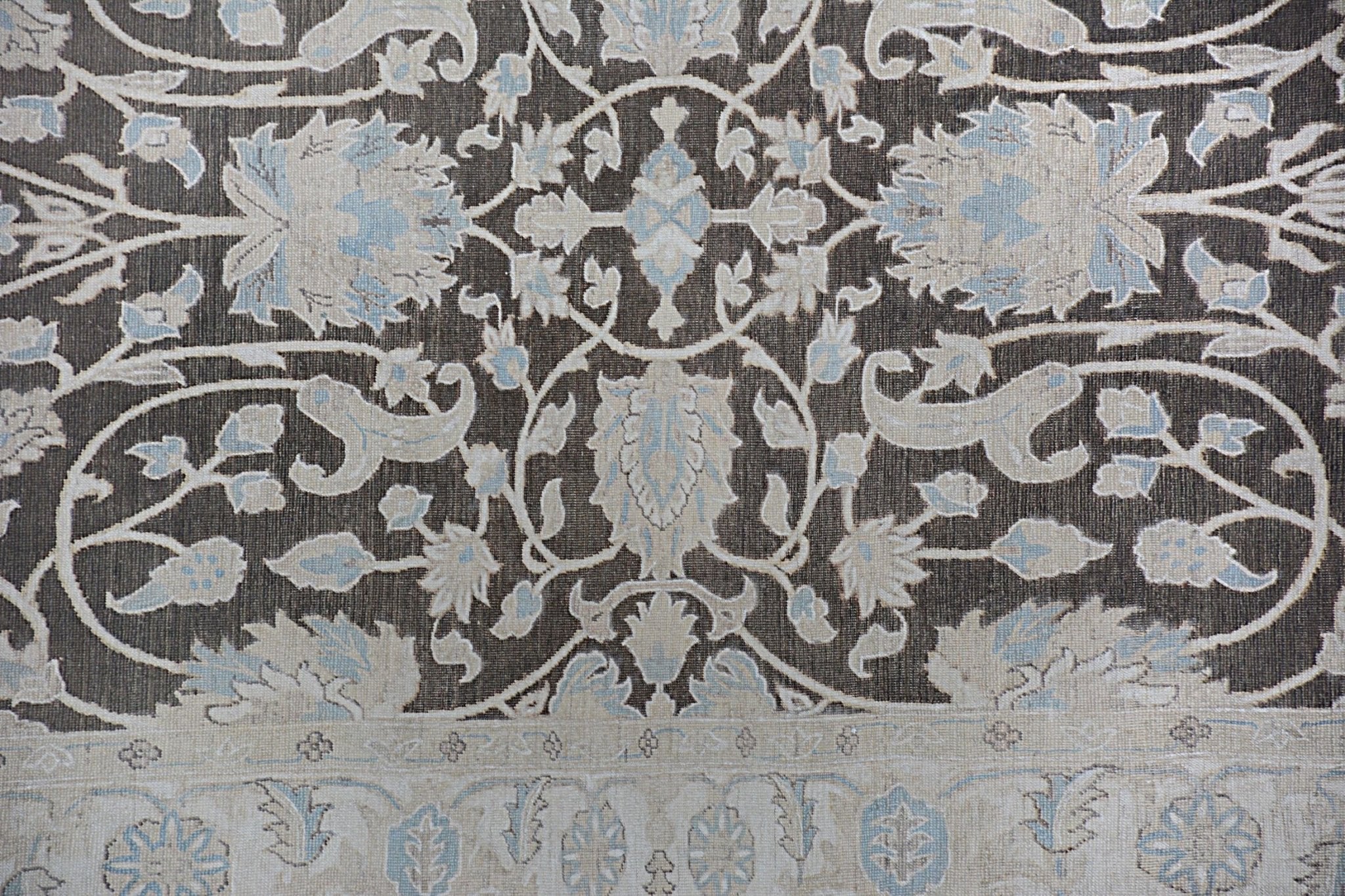 An Afghan Chobi rug featuring a traditional floral pattern in shades of brown, cream, and blue.
