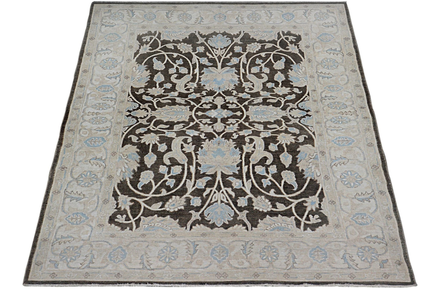 Handmade Afghan Chobi rug featuring a dark brown field with intricate light blue floral patterns.