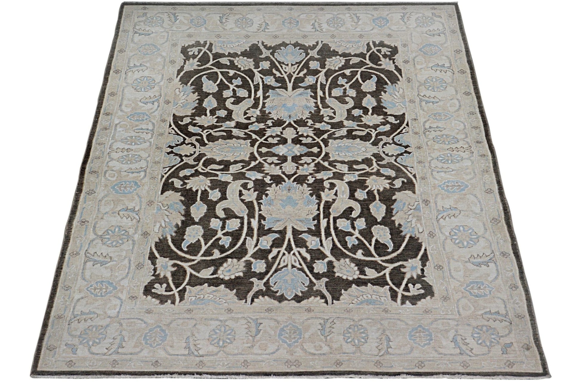 Handmade Afghan Chobi rug featuring a dark brown field with intricate light blue floral patterns.