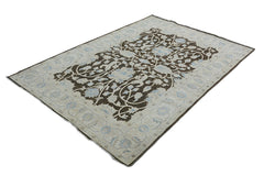 A handmade Afghan Chobi rug featuring a dark brown floral pattern on a light beige background.