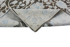 A handmade Afghan Chobi rug featuring a floral pattern in brown, cream, and light blue tones.