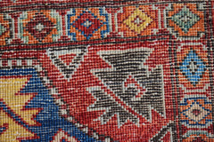 A close-up of a handmade Afghan Chobi rug featuring intricate geometric patterns in vibrant colors.