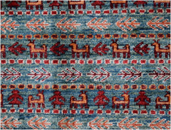 Handmade Afghan Chobi rug featuring a blue field with repeating animal and floral motifs.