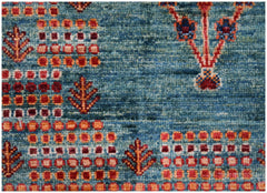 A handmade Afghan Chobi rug featuring a blue field with geometric patterns and floral motifs.