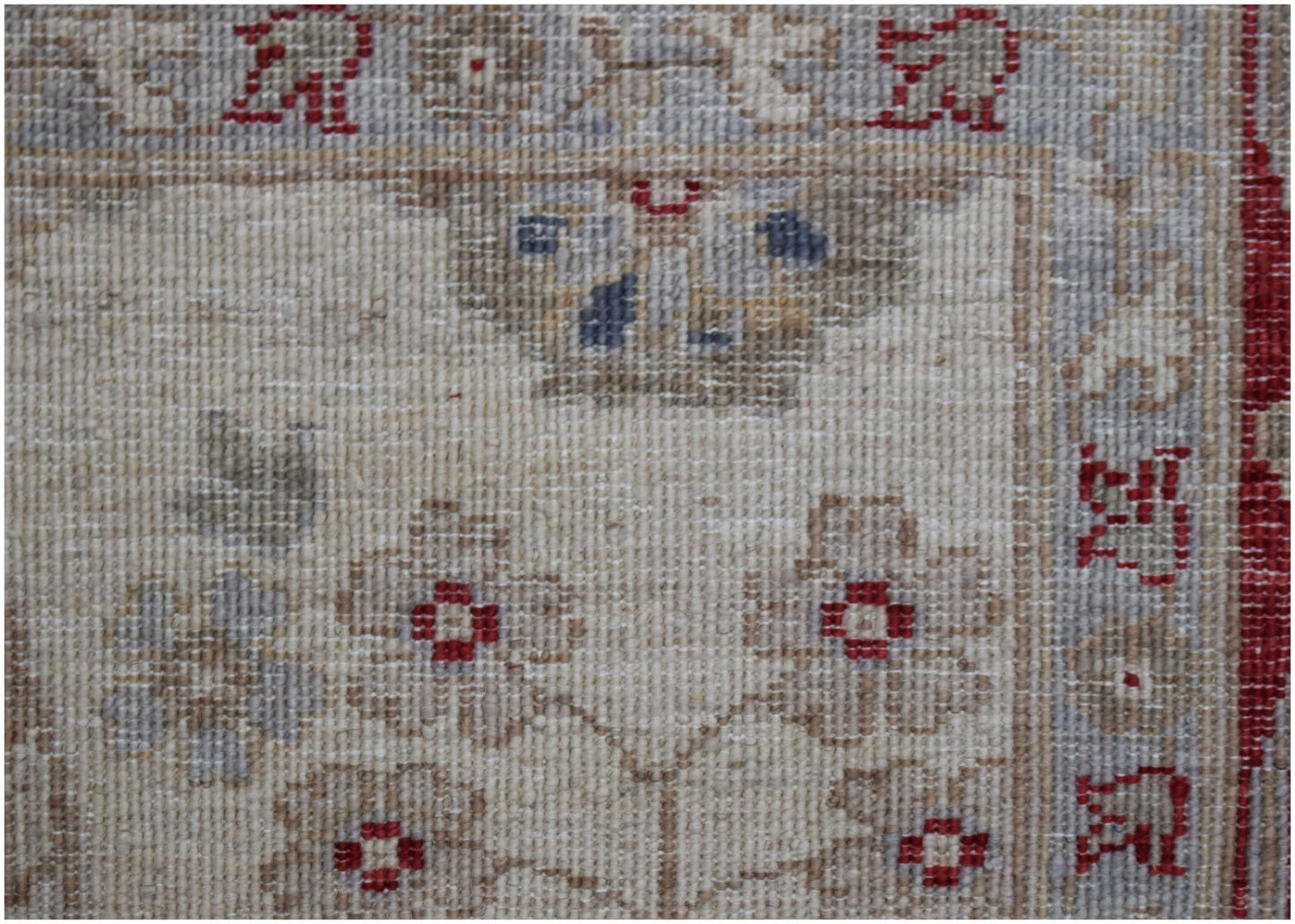 A close-up of an Afghan Chobi rug featuring floral patterns in muted tones on a cream background.