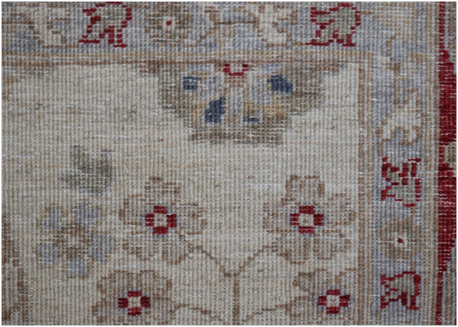 A close-up of an Afghan Chobi rug featuring floral patterns in muted tones on a cream background.