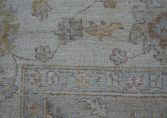A close-up of a handwoven Afghan Chobi rug featuring traditional floral patterns in muted tones.