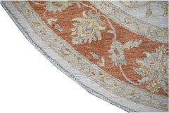 A close-up of a round Afghan Chobi rug featuring a terracotta border with floral patterns.