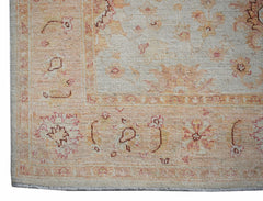 A handmade Afghan Chobi rug featuring a traditional floral pattern in soft peach and cream tones.