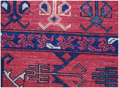 A close-up of a handwoven Afghan Chobi rug featuring traditional geometric patterns in red and blue.