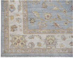 A handmade Afghan Chobi rug featuring a blue field with floral patterns and a cream border.
