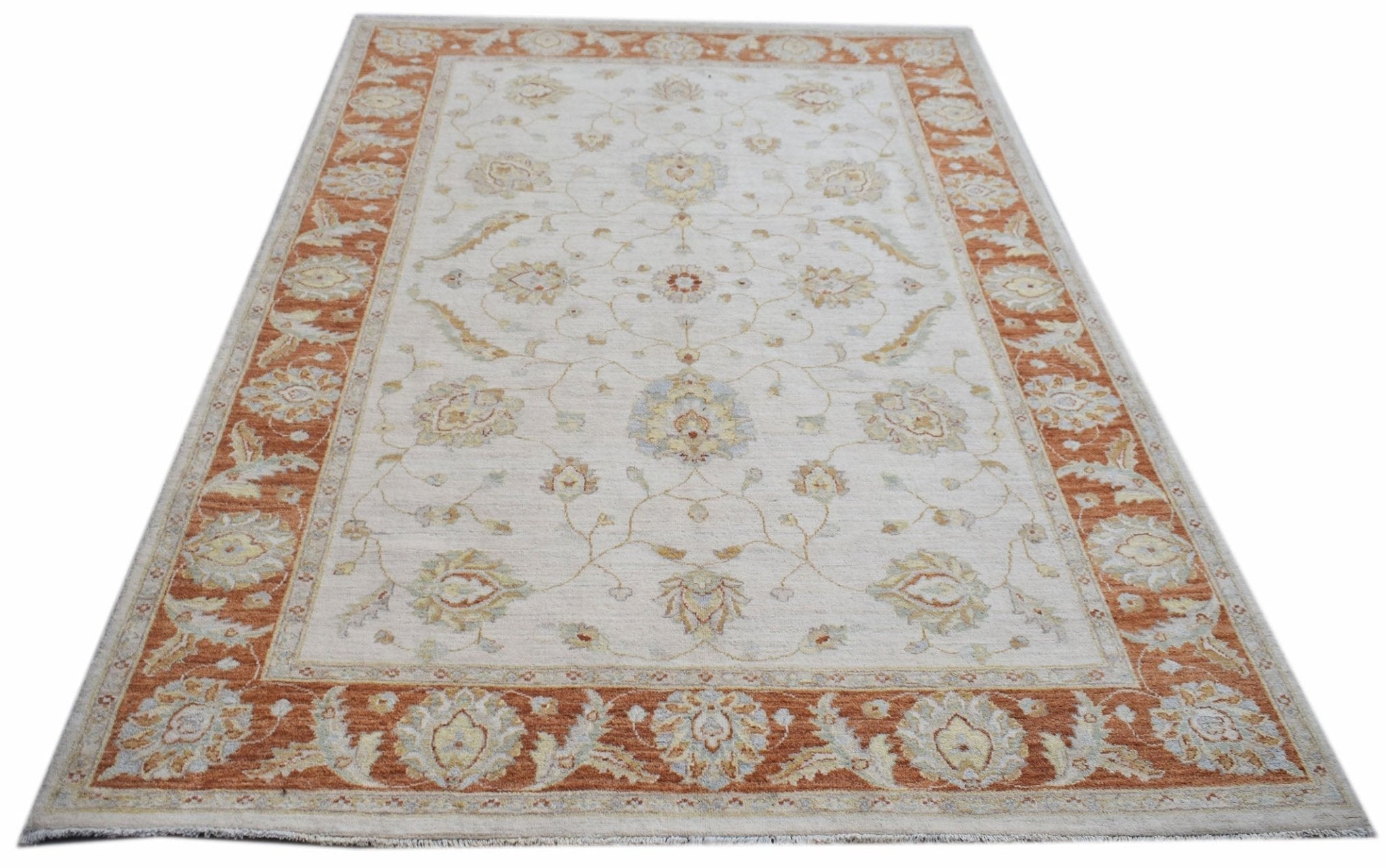 An Afghan Chobi rug featuring a traditional floral pattern in soft orange and cream tones.