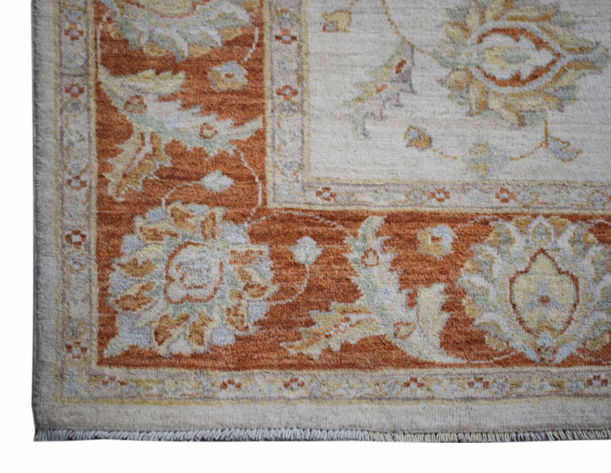 A handwoven Afghan Chobi rug featuring a traditional floral pattern in rust and cream tones.
