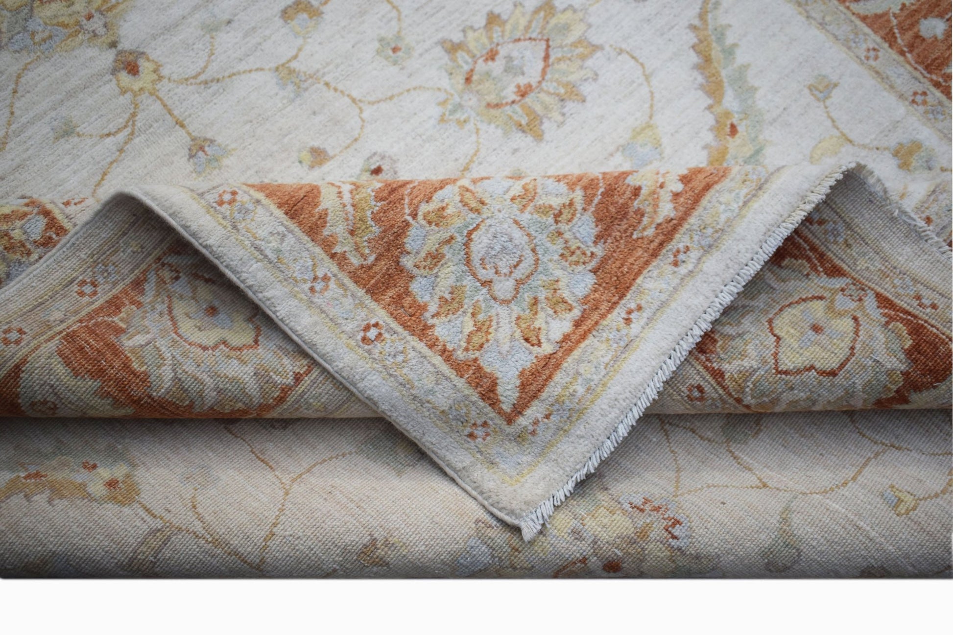 A handwoven Afghan Chobi rug featuring a floral pattern in soft orange and cream tones.