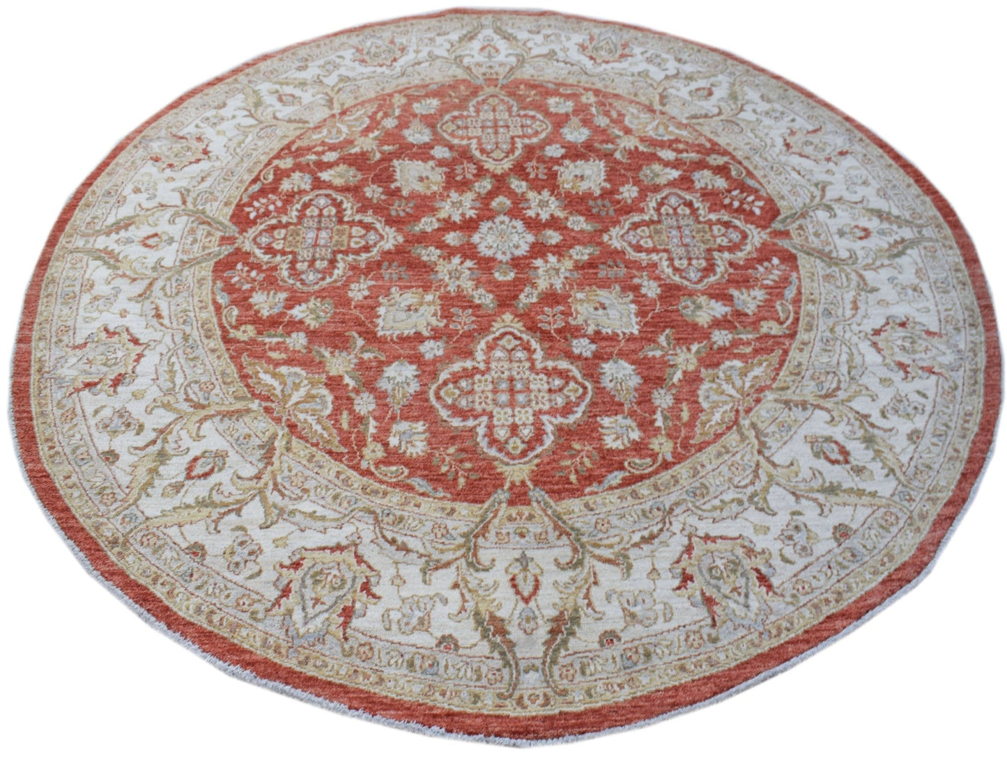 A round Afghan Chobi rug featuring a traditional floral pattern in shades of terracotta and cream.