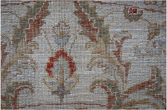 A close-up of a handwoven Afghan Chobi rug featuring traditional floral patterns in earthy tones.