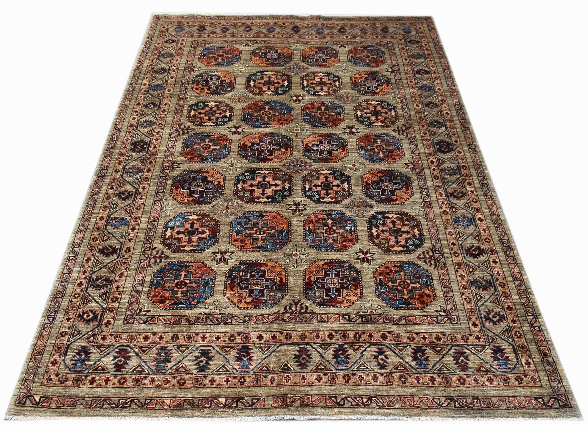 Handmade Afghan Chobi rug featuring a repeating geometric medallion pattern in earthy tones.