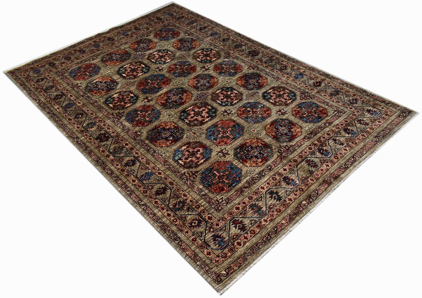 Handwoven Afghan Chobi rug featuring a repeating geometric medallion pattern in earthy tones.
