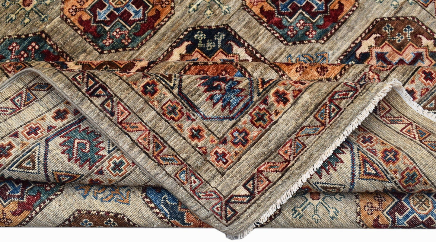 A handwoven Afghan Chobi rug featuring geometric patterns in earthy tones on a light background.