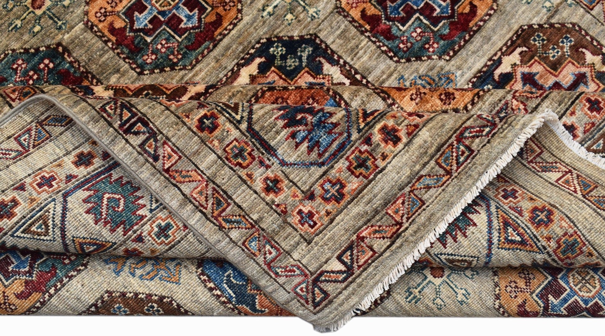 A handwoven Afghan Chobi rug featuring geometric patterns in earthy tones on a light background.