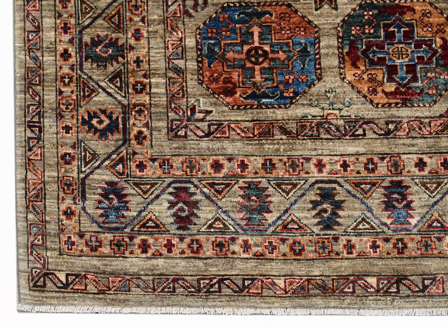 A handmade Afghan Chobi rug featuring traditional geometric patterns in earthy, wood-toned colors.