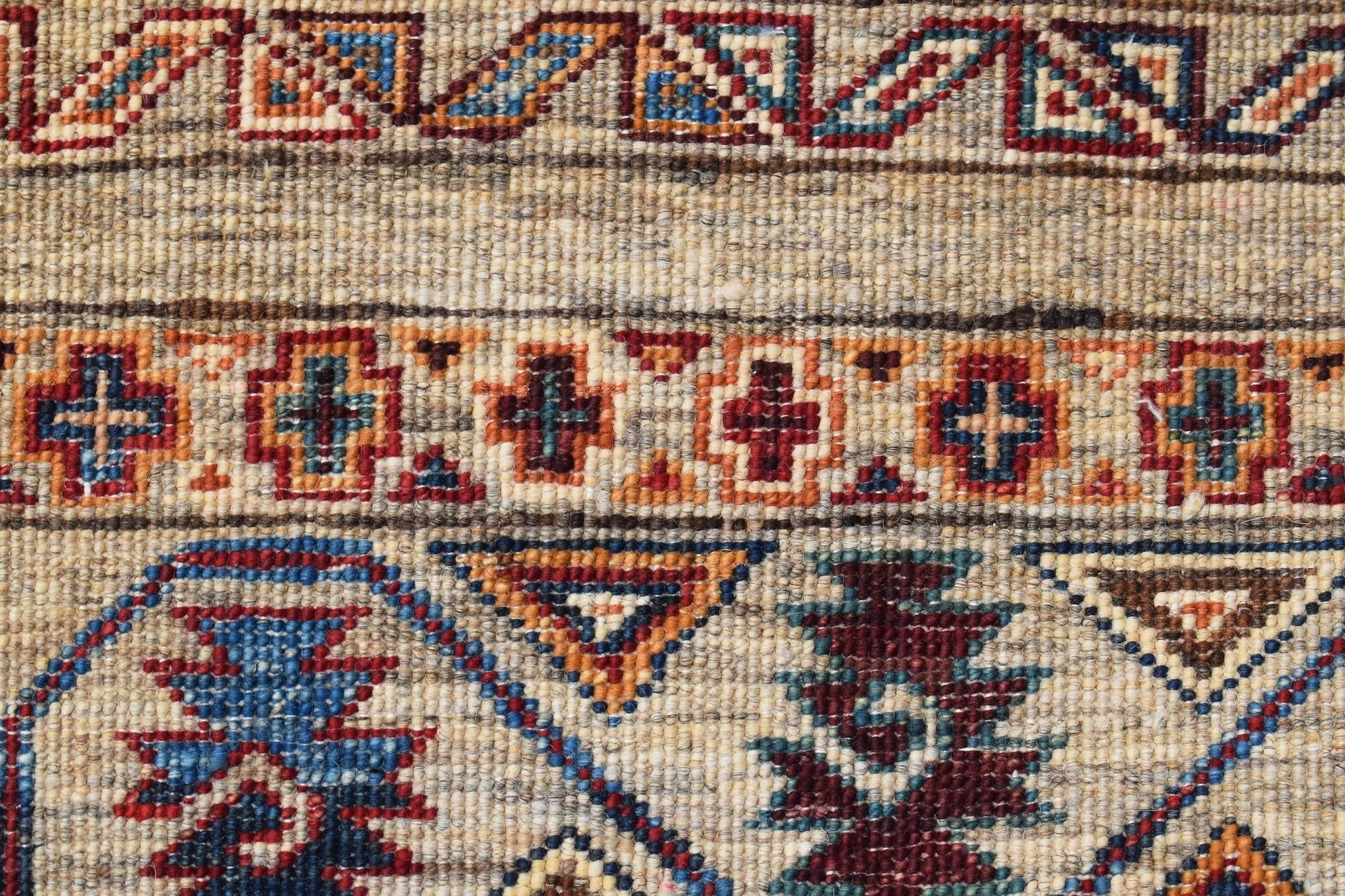 A close-up of a handwoven Afghan Chobi rug featuring geometric patterns in earthy tones.