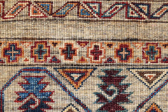 A close-up of a handwoven Afghan Chobi rug featuring geometric patterns in earthy tones.