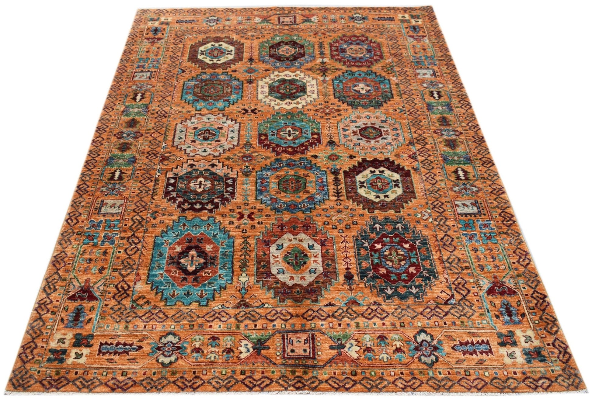 Handwoven Afghan Chobi rug featuring a traditional geometric pattern in warm orange and blue tones.