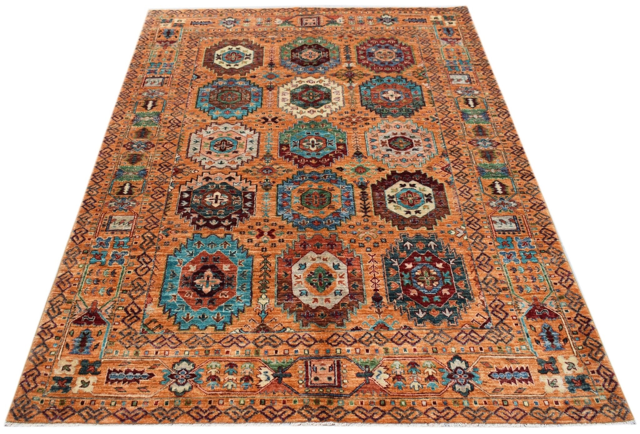 Handwoven Afghan Chobi rug featuring a traditional geometric pattern in warm orange and blue tones.