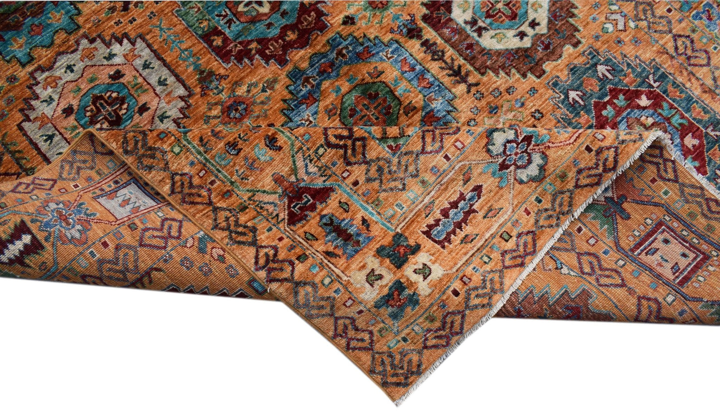 A handwoven Afghan Chobi rug featuring a traditional geometric pattern in warm orange and blue tones.