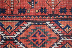 A close-up of an Afghan Chobi rug featuring intricate geometric patterns in red, blue, and white.