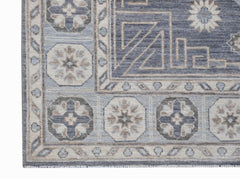A handwoven Afghan Chobi rug featuring geometric floral motifs in shades of blue, grey, and beige.