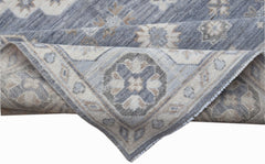 A handwoven Afghan Chobi rug featuring a traditional geometric pattern in shades of blue and beige.
