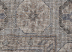 A close-up of a handwoven Afghan Chobi rug featuring a traditional geometric pattern in neutral tones.
