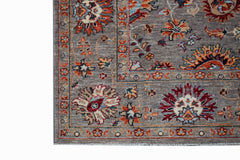 A handwoven Afghan Chobi rug featuring a traditional floral pattern in earthy tones on a grey base.
