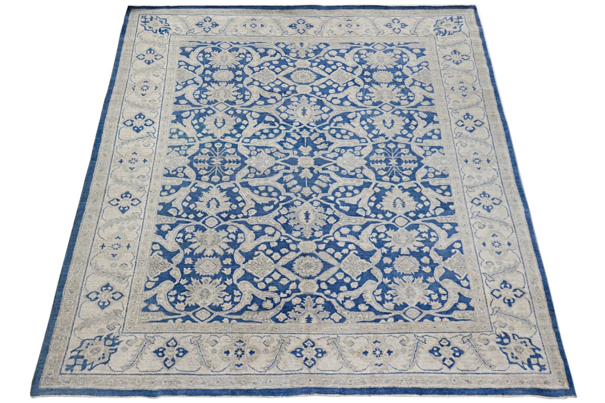 A rectangular Afghan Chobi rug featuring a blue and cream floral pattern with a decorative border.
