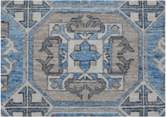 A handmade Afghan Chobi rug featuring a geometric medallion pattern in blue, beige, and grey.