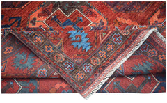 A handwoven Afghan Chobi rug featuring traditional geometric patterns in red, blue, and brown.