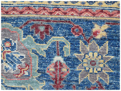 A close-up of a handwoven Afghan Chobi rug featuring intricate floral patterns in blue and red.