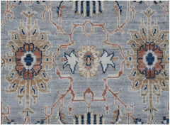 An Afghan Chobi rug featuring a traditional floral pattern in blue, tan, and rust on a grey field.