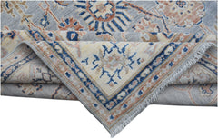 A folded Afghan Chobi rug featuring a traditional geometric pattern in blue, cream, and tan tones.