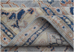 A folded Afghan Chobi rug featuring a traditional pattern in shades of blue, cream, and tan.